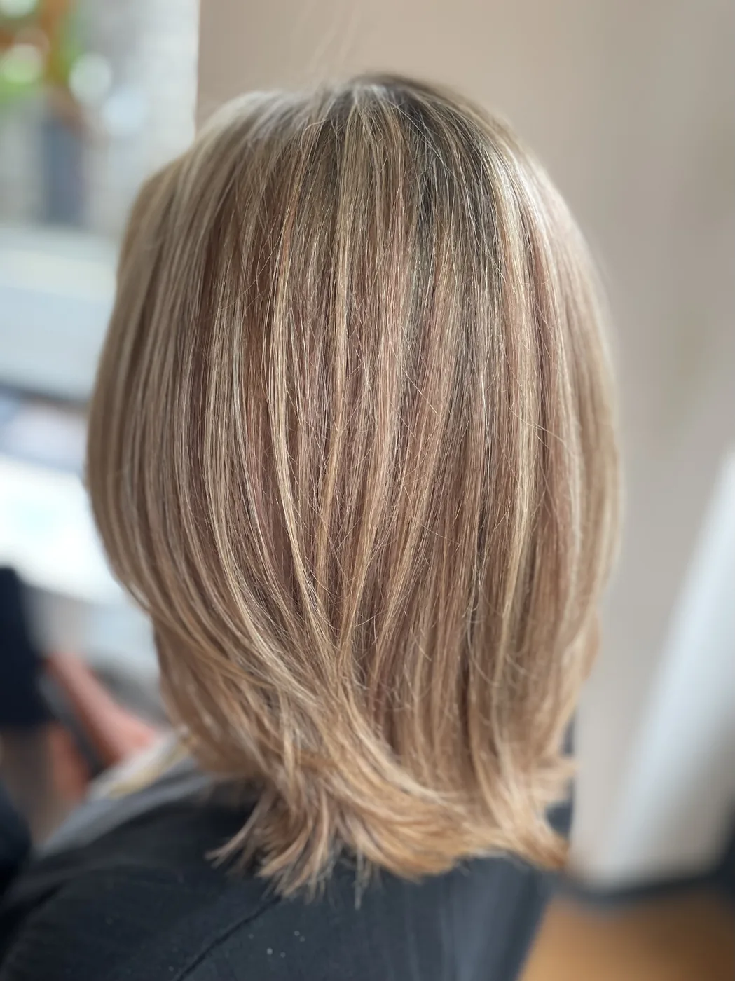 Hair color after the second color correction appointment, moving toward blonde.