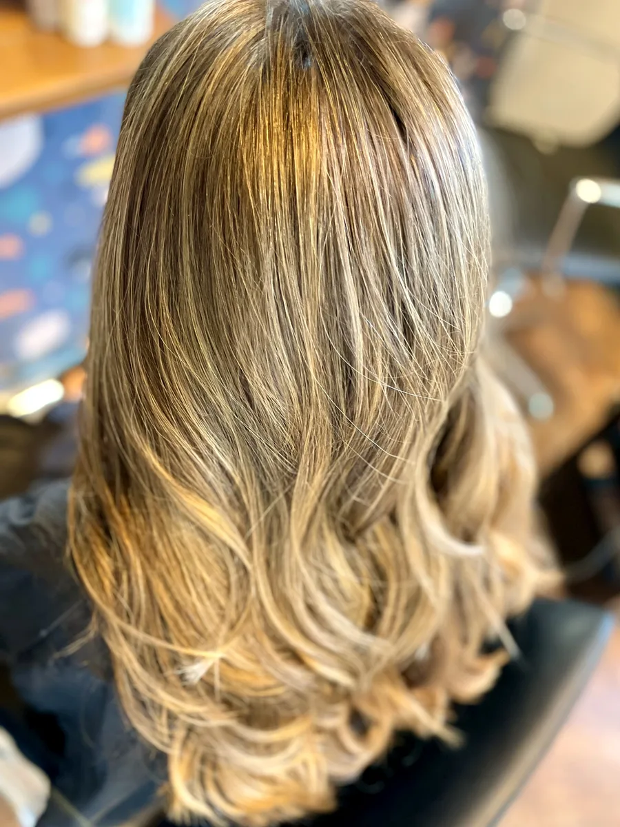 Golden bronde balayage with soft, brushed-out waves — dimensional color, back view.