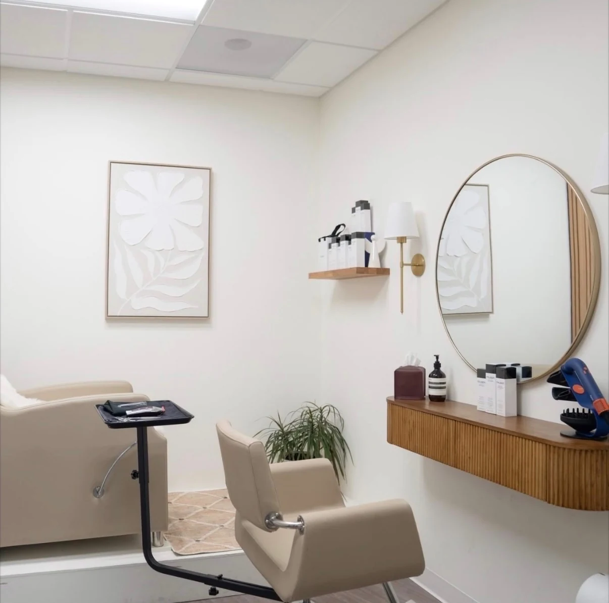 Anna's private suite — styling chair, round mirror, and calm neutral tones.